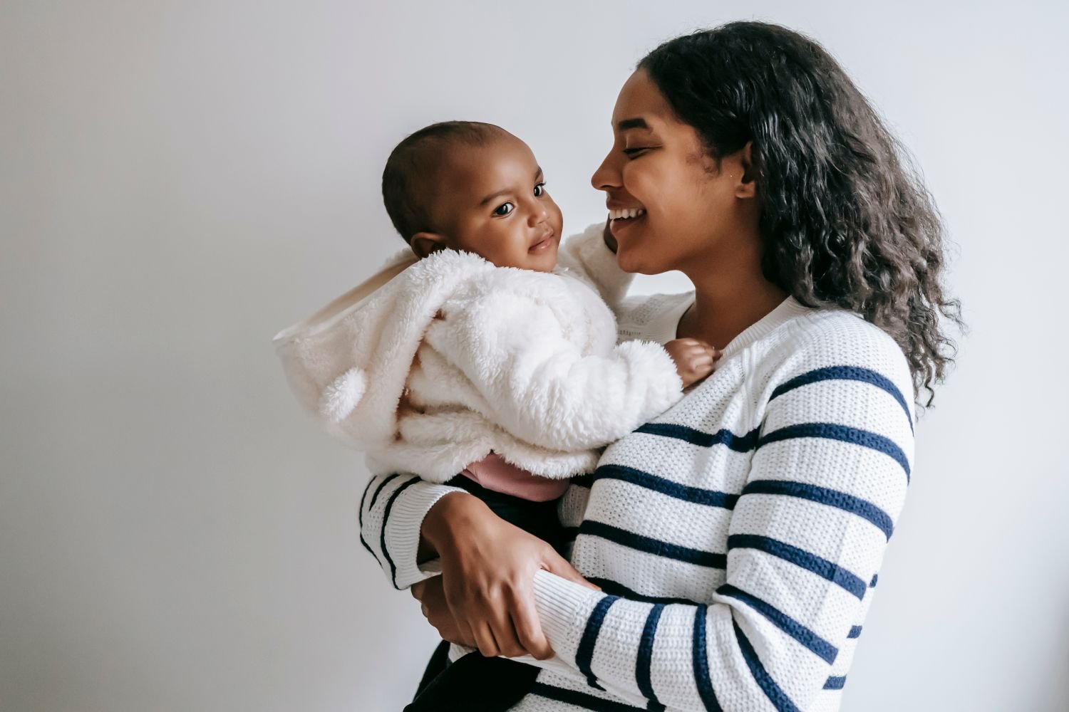 Mother holding her newborn baby at home